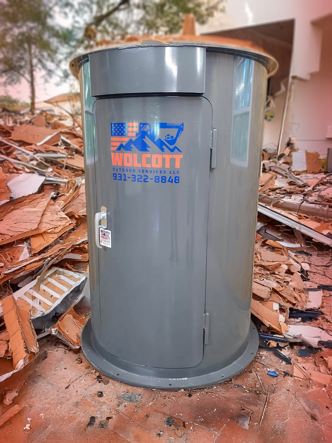 A tall, grey Wolcott Outdoor Services LLC storm shelter 